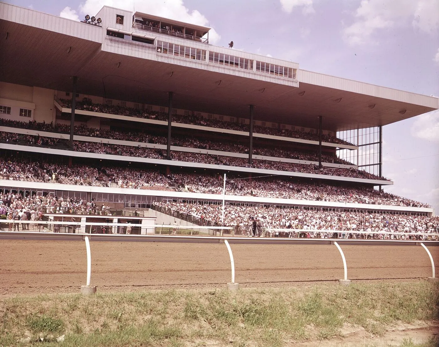 Archival photograph of the Woodbine grandstand seen from track level, decks full of spectators