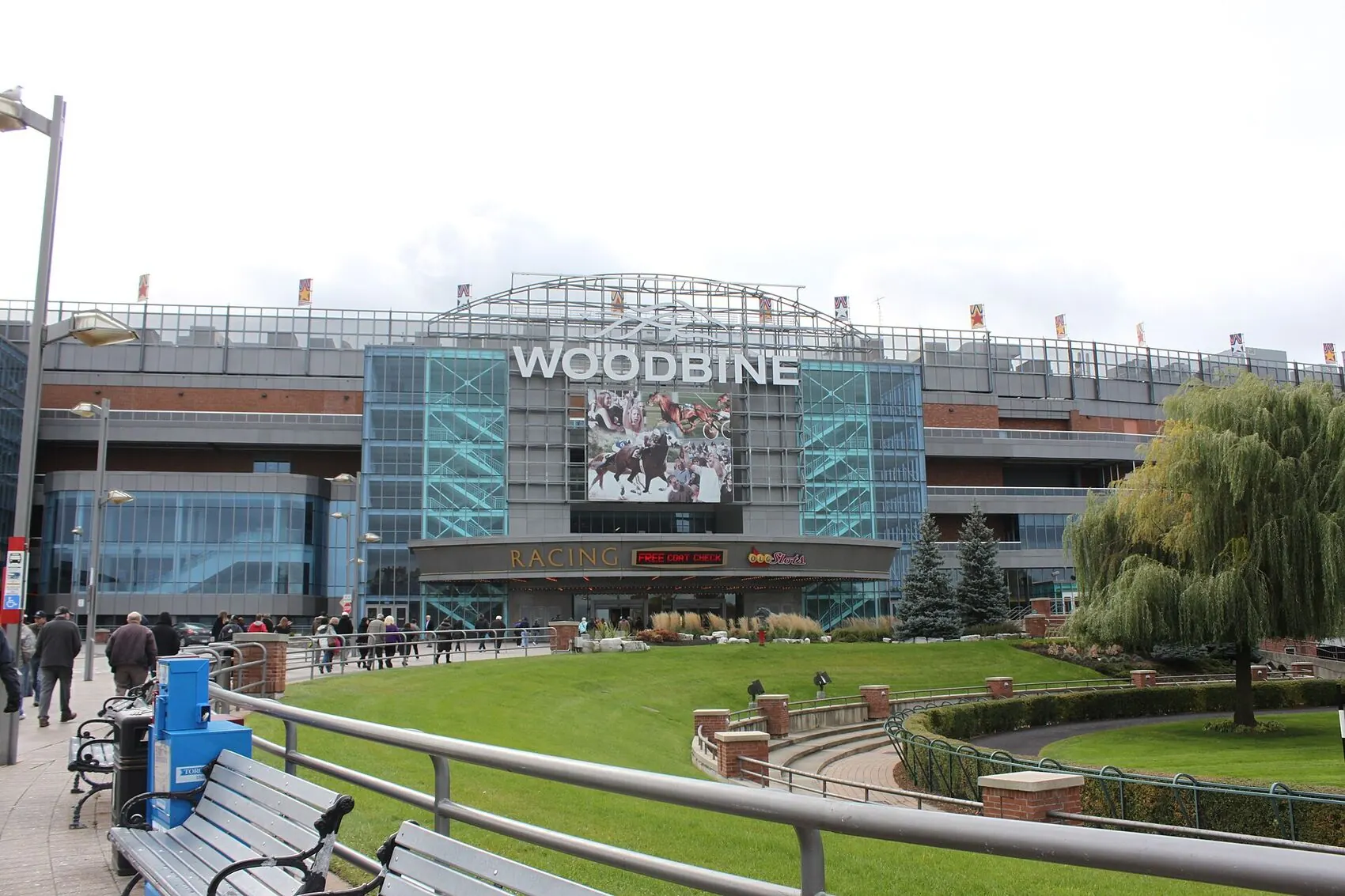 The Woodbine grandstand seen across the entrance lawn in Toronto, with the WOODBINE lettering above the glass facade